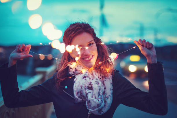 istock Redhead woman pulling apart garland fairy lights 964899792