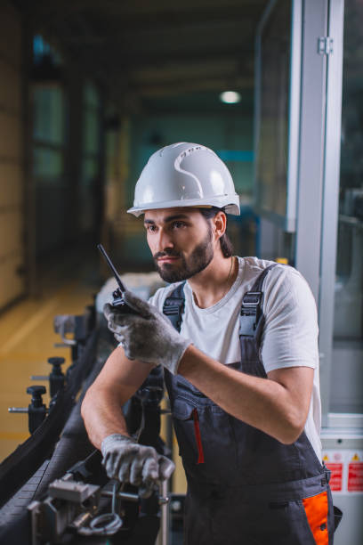 istock Factory worker controlling production and talking with colleague on walkie-talkie 964900152