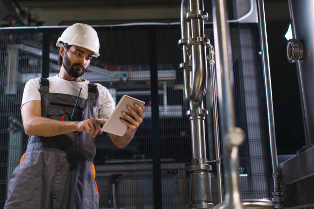 istock Young male engineer in factory controlling production 964908188