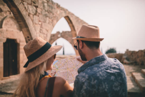 istock Young tourists reading map at old Mediterranean stonebuilt village 964908346