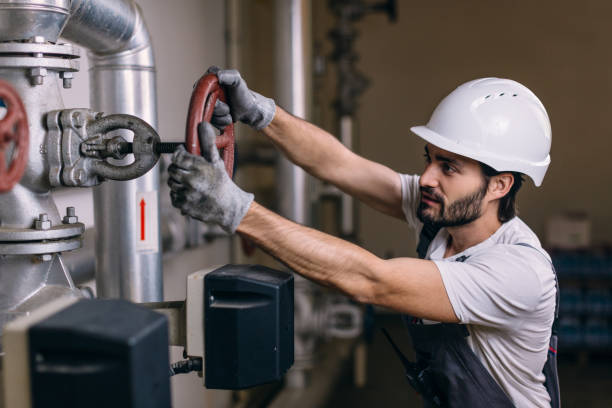 istock Worker with helmet in front of pipes with valves 964908664