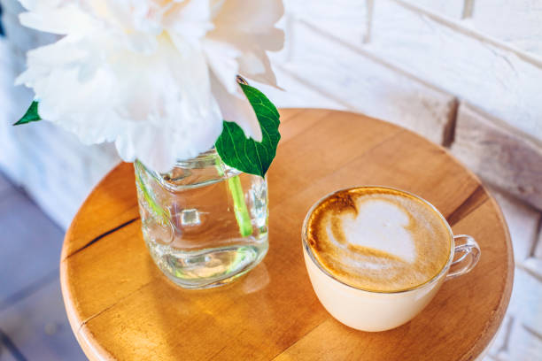 istock A cup of cappuccino in a cafe on white brick wall background 964908740