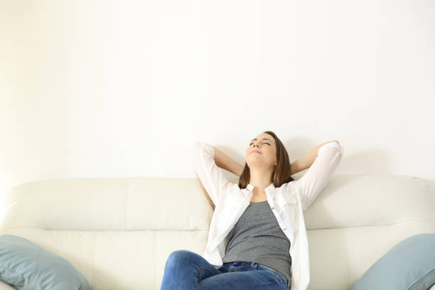 Woman relaxing on a couch with copy space above Wide angle view portrait of a woman relaxing on a couch with copy space above hot cool stock pictures, royalty-free photos & images