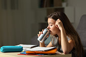Studious teen studying drinking energy beverage