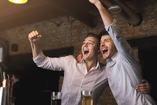 Successful businessmen drinking beer and shouting at the bar