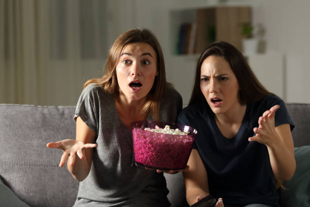istock Frustrated friends watching tv in the night 964915554