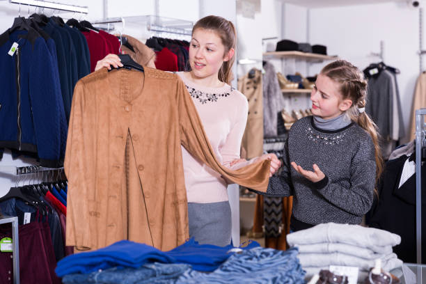 istock Daughter with mother choosing clothes in store 964916590