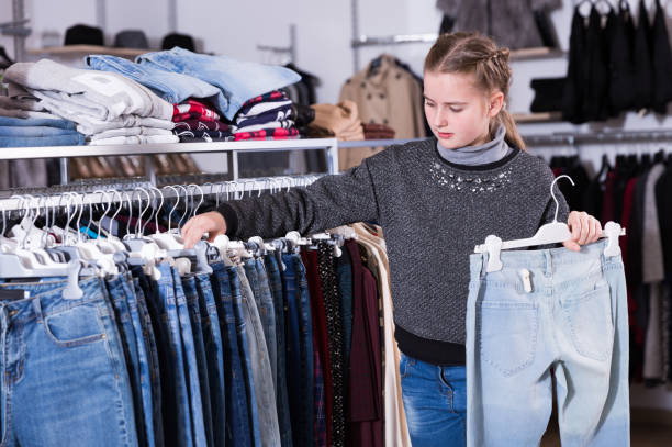 istock Girl choosing jeans in store 964916818