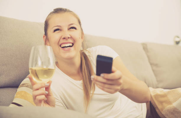 istock Girl is resting with wine and watching TV 964916858