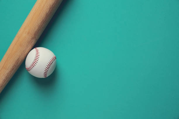 istock baseball and baseball bat on green background, close up 964917250