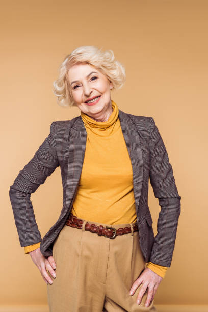 istock stylish senior woman posing isolated on beige background 964926418