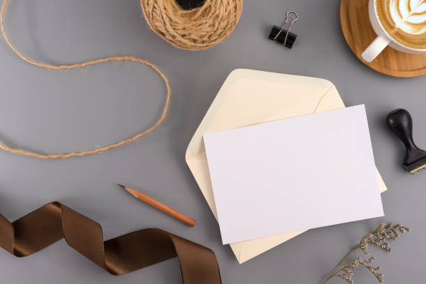 istock A wedding concept. Wedding Invitation, envelopes, cards Papers on grey background with ribbon and decoration. Top view, flat lay, copy space 964929156