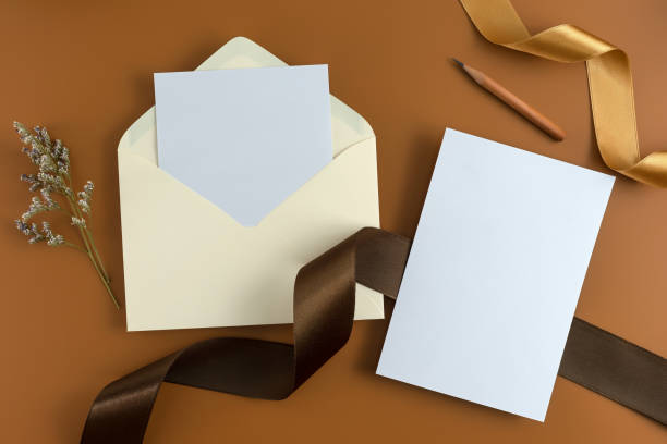 istock A wedding concept. Wedding Invitation, envelopes, cards Papers on brown background with ribbon and decoration. Top view, flat lay, copy space 964929248