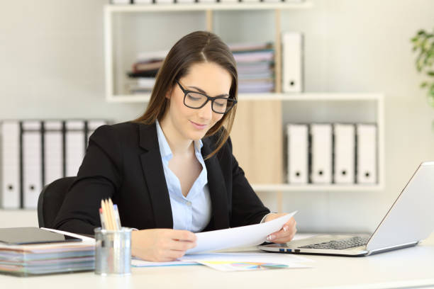 istock Office worker wearing eyeglasses reading a report 964929274