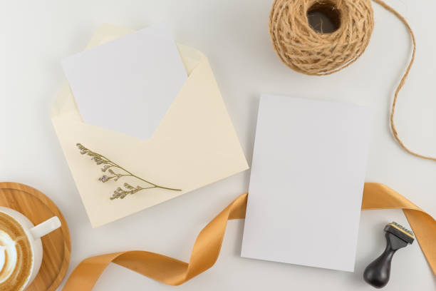 istock A wedding concept. Wedding Invitation, envelopes, cards Papers on white background with ribbon and decoration. Top view, flat lay, copy space 964929276