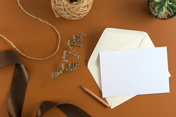 istock Wedding composition. Wedding Invitation, envelopes, cards Papers on brown background with ribbon and decoration. Top view, flat lay, copy space 964929392