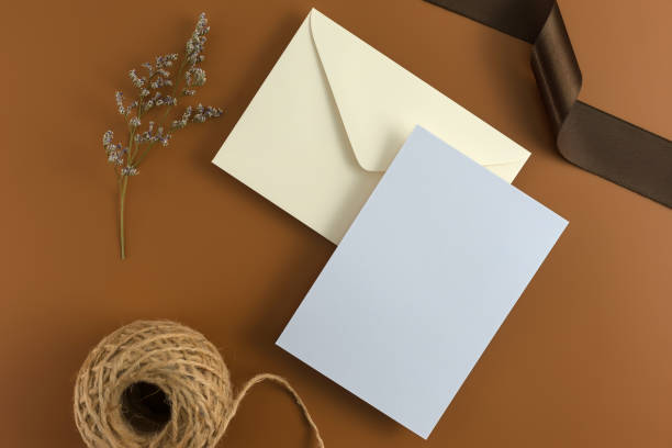 istock A wedding concept. Wedding Invitation, envelopes, cards Papers on brown background with ribbon and decoration. Top view, flat lay, copy space 964929398