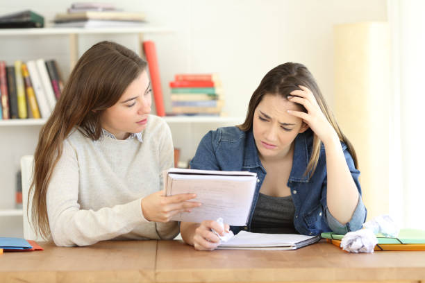 istock Student helping her frustrated friend to learn lesson 964932518