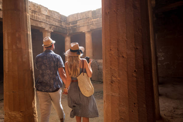 istock Young tourists couple walking into ancient stone columns monument 964932538