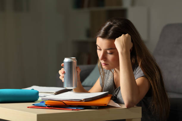 istock Student memorizing holding and energy drink in the night 964932604