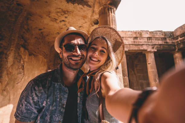 Young tourists couple taking selfies at ancient monument in Italy Smiling tourists on summer vacations in Greece taking selfies at ancient landmark with stone columns selfie photos stock pictures, royalty-free photos & images