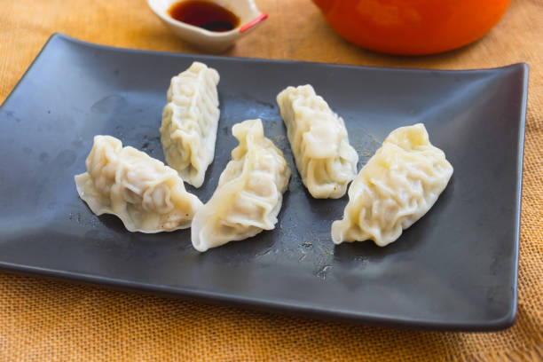 istock Steamed dumplings on a black plate, asian style appetizer 964936880