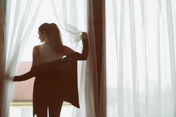 istock Young woman looking out the window 964941610