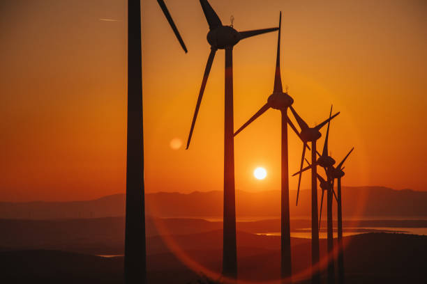 Aerial view large group of eco system wind turbines power generation station on green field in rural landscape in countryside in sunny summer sunshine time. xxxl size
