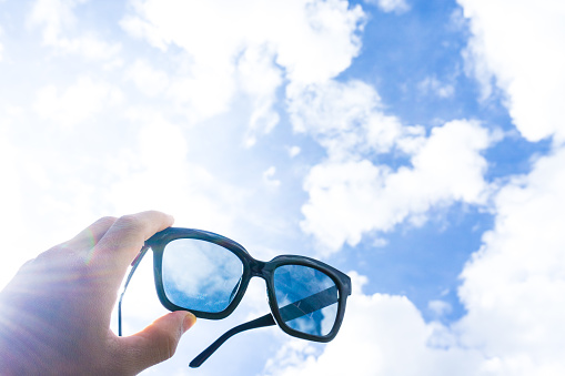 Black sunglasses with bright sky, cloud for readiness.