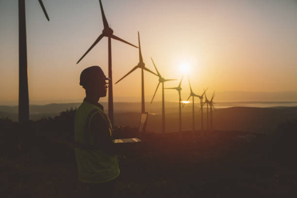 istock Young maintenance engineer man working in wind turbine farm at sunset 964951226