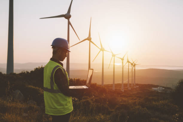 istock Young maintenance engineer man working in wind turbine farm at sunset 964951936
