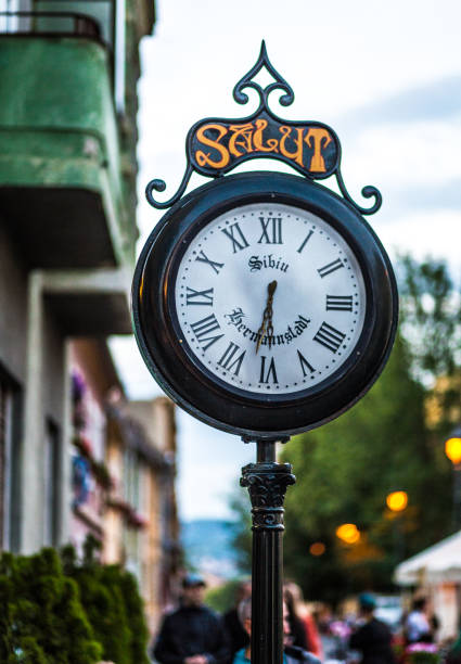 Close up color image depicting an old fashioned clock outdoors on the ancient, medieval street of Sibiu, a city in the Transylvania region of Romania.