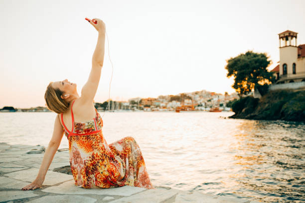 istock Charming young woman using phone and taking selfie during her vacation 964955714