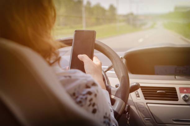 istock Woman using phone while driving the car 964955998