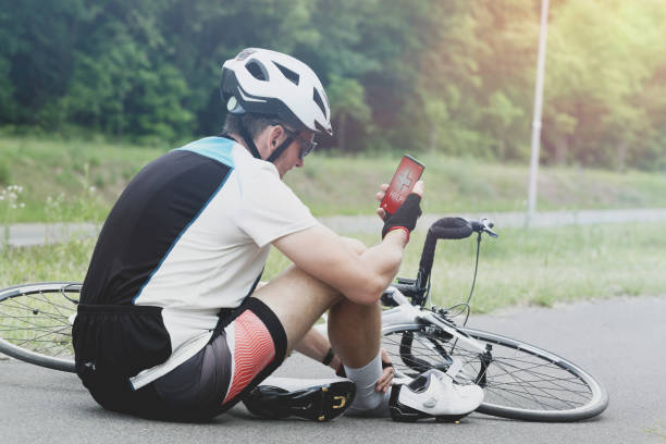 istock Injured biker holding his smartphone calling rescue team 964958450