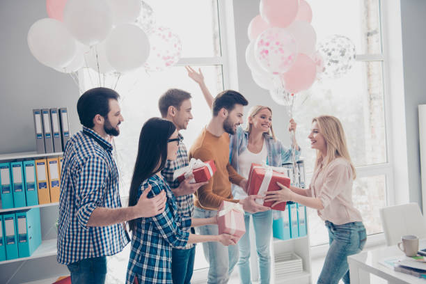 créatif, élégant, gens d’affaires attrayant, gai donnant des cadeaux, cas en paquet avec se plier à leur heureux assez charmante belle anniversaire fille, collègue, gestionnaire - men giving balloon women photos et images de collection