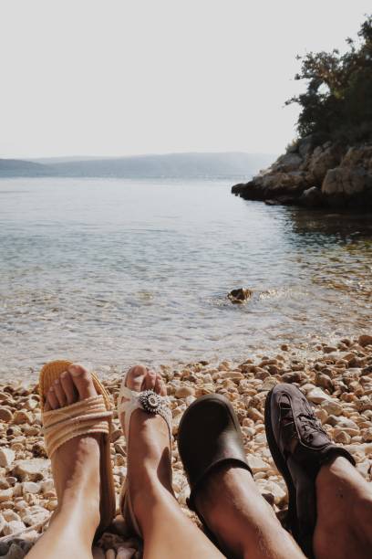 istock Couple wearing trash / plastic shoes on the beach 964966348