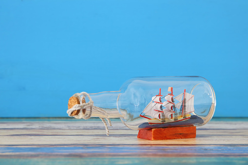 imagen de concepto náutico con velero en la botella sobre la mesa de madera. Enfoque selectivo. photo