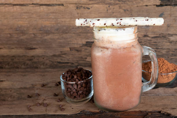 istock Chocolate and cocoa mixed with milk smoothies on wooden floor. 964966854