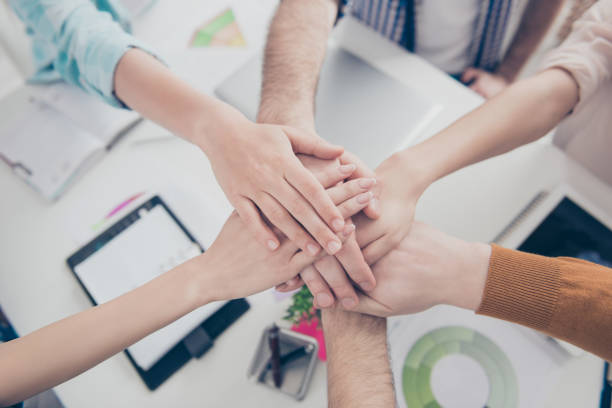 istock Agreement, achievement, handshake motivation connection concept. Cropped top high angle view close up portrait of business people's palms putting on top of each other in modern place, station 964970116