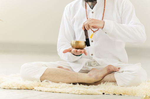 Guru practicing kundalini yoga and meditation with a singing bowl