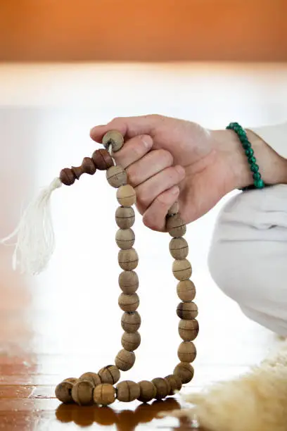 Man practicing kundalini yoga and meditation with buddhist prayer beads