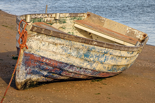 Closeup of old wooden boat ashore during low tide.
