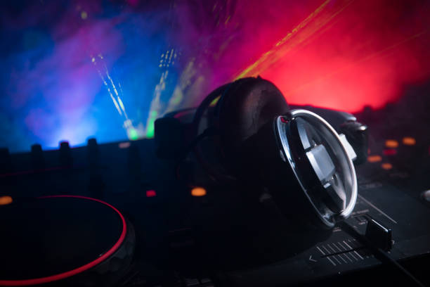 istock In selective focus of Pro dj controller.The DJ console deejay mixing desk at music party in nightclub with colored disco lights. 964985406