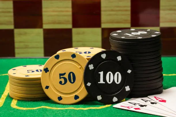 Photo of columns of poker chips and a combination of four aces