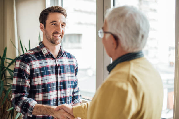 istock Happy young man shaking hands with old man 965002792