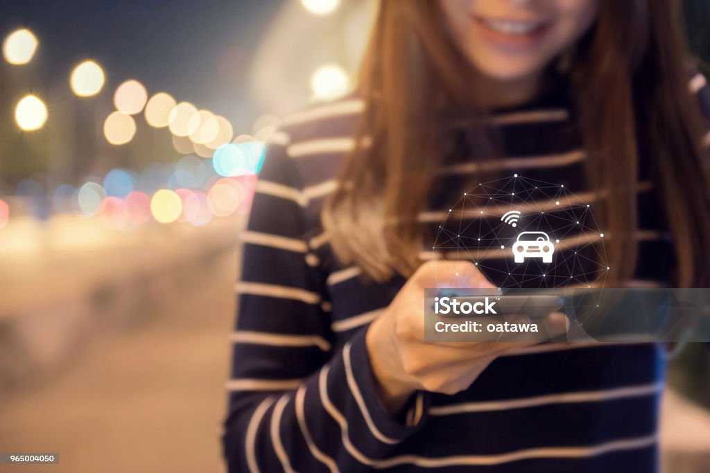 Close up woman hand orders a taxi from his mobile smartphone application. Car Stock Photo