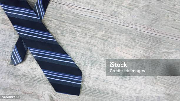 Striped Blue And Black Tie Over Wood Stock Photo - Download Image Now - Necktie, Tying, Table