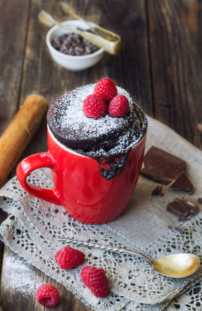 istock Fresh homemade chocolate cake in mug on rustic wooden background. 965015044