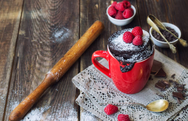 istock Fresh homemade chocolate cake in mug on rustic wooden background. 965015046
